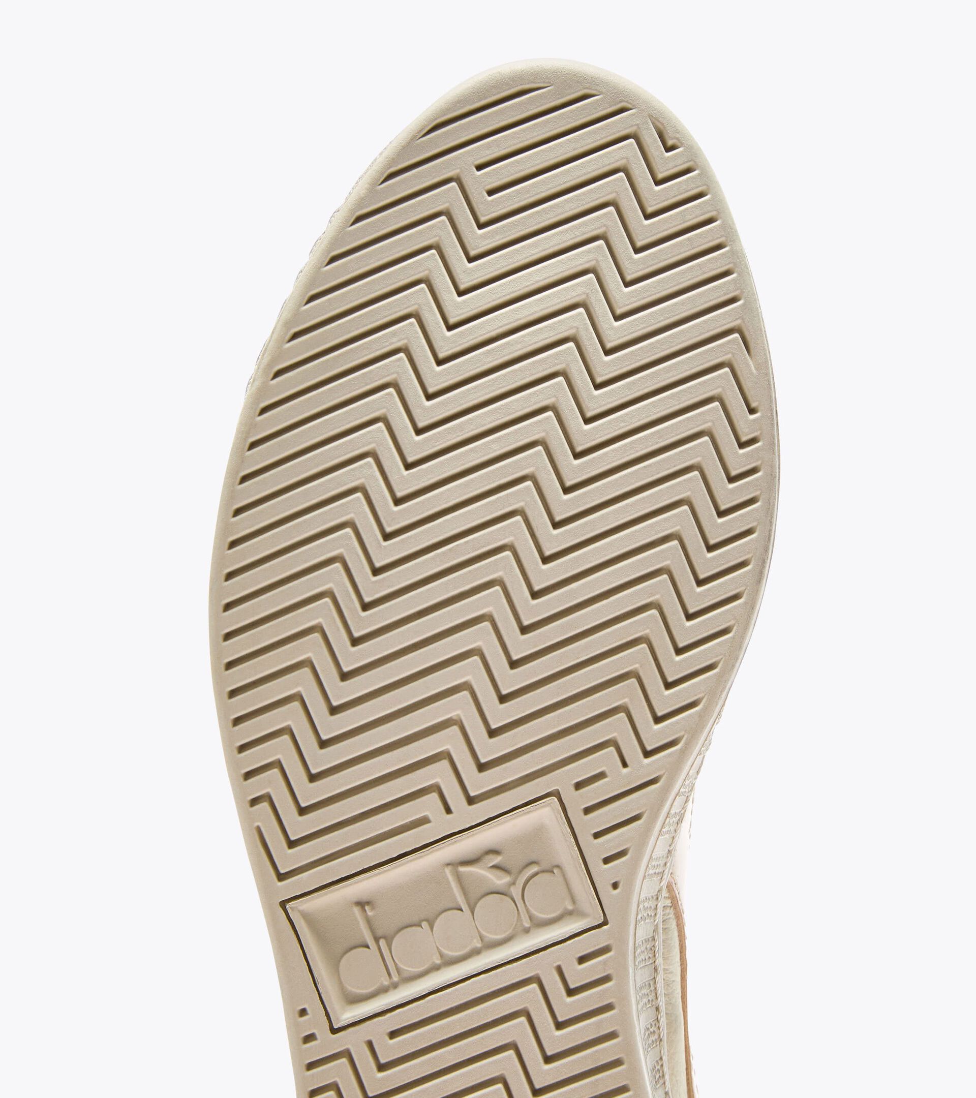 Zapatilla deportiva de piel - Mujer
GAME L LOW WAXED STUDS WN FELICIDAD PURA - Diadora